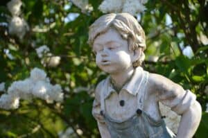 Junge als Statue im Garten